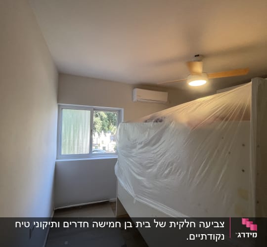 חדר צבוע עם רהיטים מכוסים בניילון